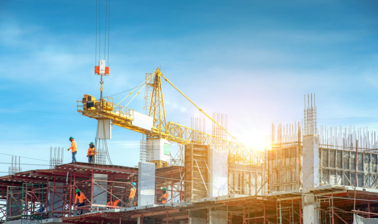 Workers are working on large construction sites and many cranes are working in the construction industry.